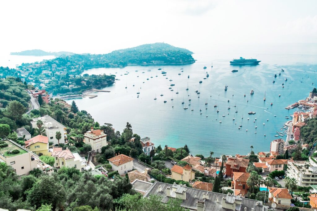 airal view of nice france with rolling hillside homes circling the ocean marina.