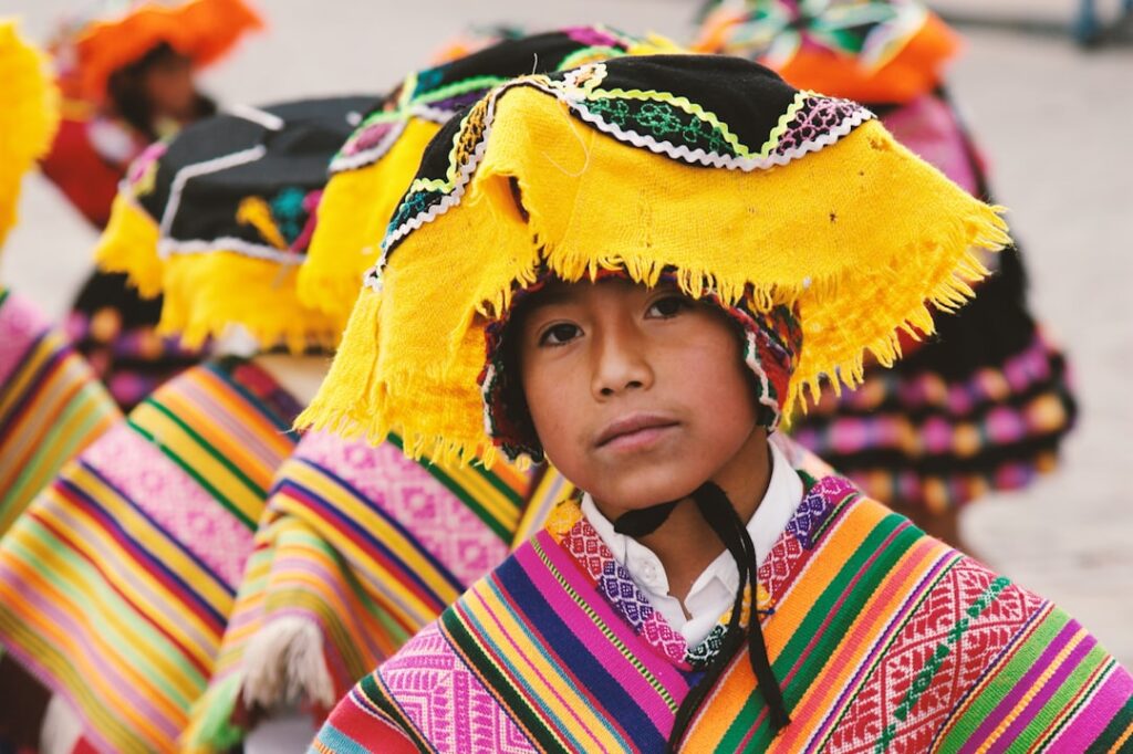 boy with bright colored headdress and woven native shaw