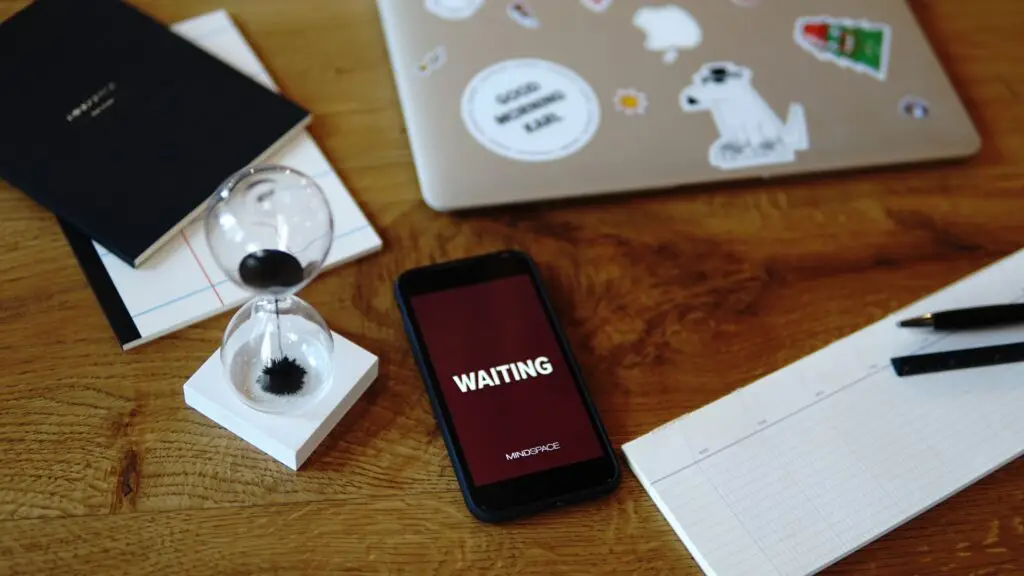 mobile phone on table next to laptop computer