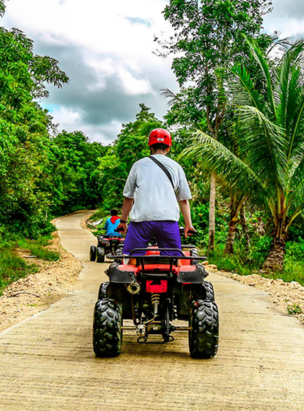 man on ATV driving on dirt road